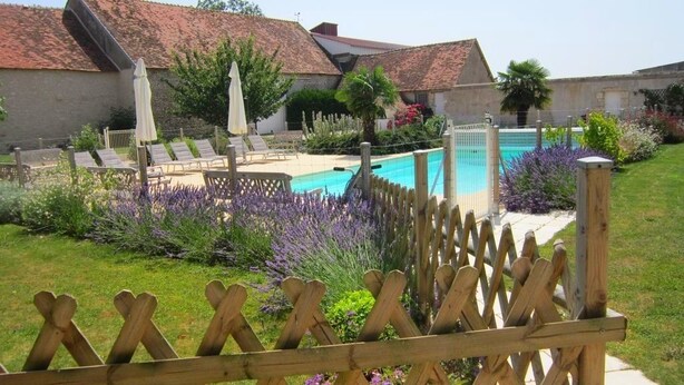 A pool area with lounge chairs and a wooden fence. - Domaine de Champouteau (Averdon)