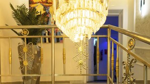 Una escalera con barandales de metal ornamentados y un candelabro.