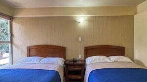 A hotel room with two beds, a ceiling fan, a nightstand, and a window. - Hotel Virginia (Oaxaca)