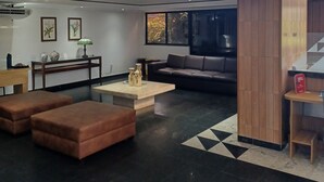 Un vestíbulo moderno con un reloj de pared grande, un sofá, una mesa de centro y una chimenea.