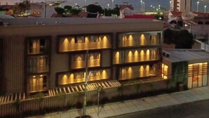 Un hotel con varios balcones, vistas al mar y un estilo arquitectónico moderno.