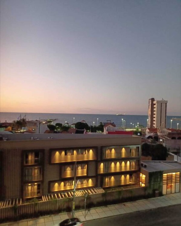 Un hôtel doté de nombreux balcons, offrant une vue sur la mer et présentant un style architectural moderne.