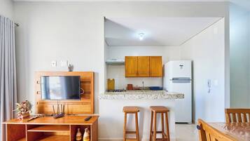 Een moderne keuken met houten kastjes, een inbouwfornuis en een witte koelkast.