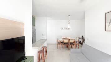 Un espacio habitable compacto con televisor, zona de estar y comedor.