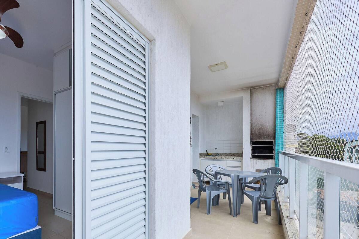 A room with a bed, a ceiling fan, and a kitchenette with a table and chairs.