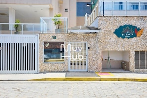 Un edificio con fachada de piedra, un letrero que dice "St. Barth Residence" y una entrada con portón.