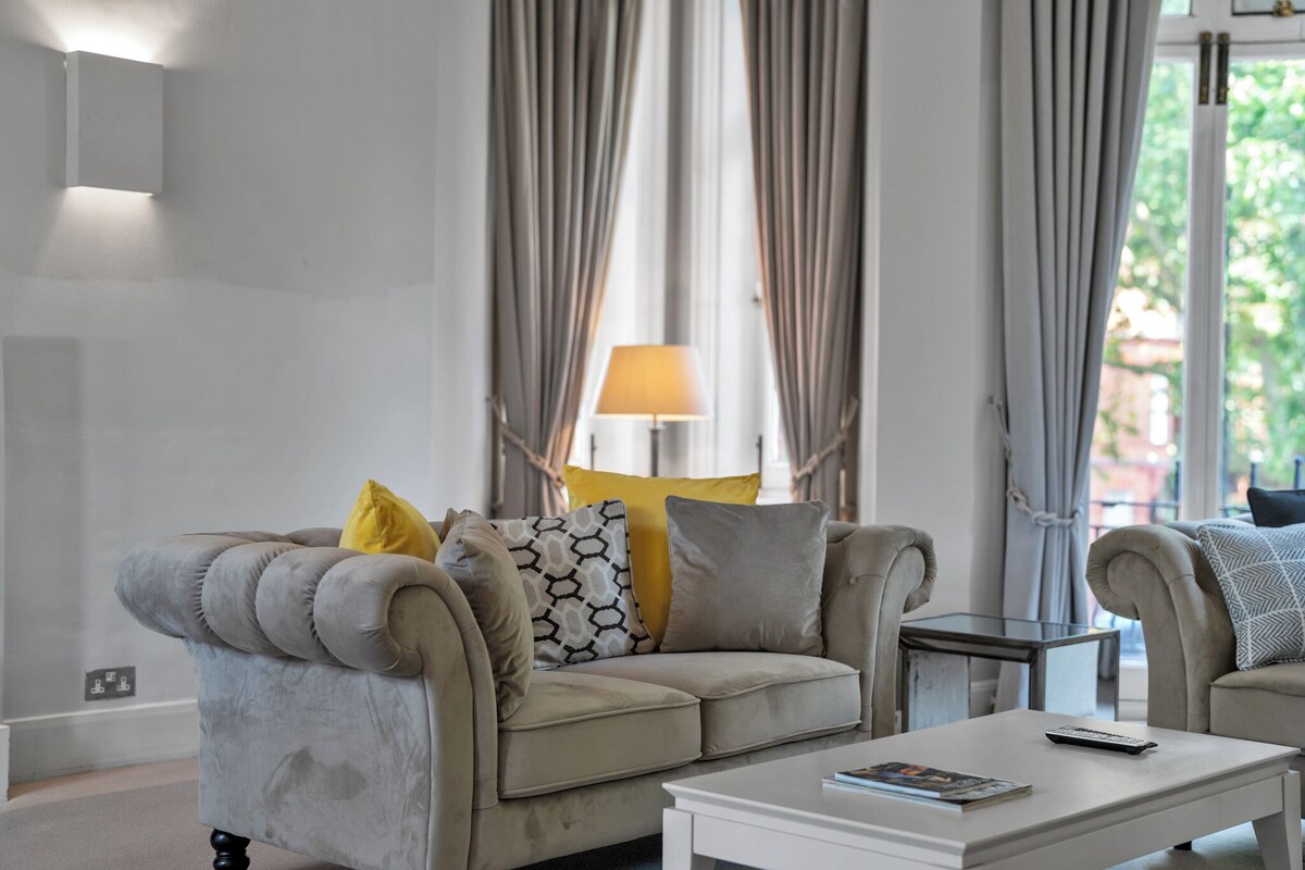 A living room with a beige sofa, a white coffee table, and a lamp.