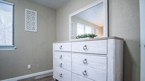 A room with a white dresser, a large mirror, and a window with blinds. - WOOD`INN - Cozy 2BD over the bridge (East Peoria)