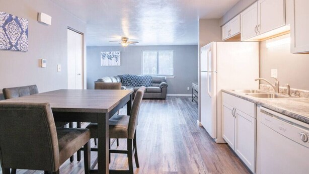 A modern kitchen with white cabinets, a granite countertop, and a built-in oven. - WOOD`INN - Cozy 2BD over the bridge (East Peoria)