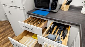 Eine Küche mit Mikrowelle, Messerblock und ordentlich organisierten Schubladen.