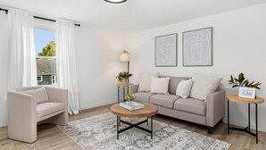 A modern living room with a sofa, a coffee table, and a side table. - Halcyon Haven - A Heavenly Homestead for 4 (Morton)