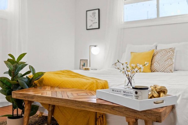 A neatly arranged bedroom with a bed, bedside table, and a bedside lamp.