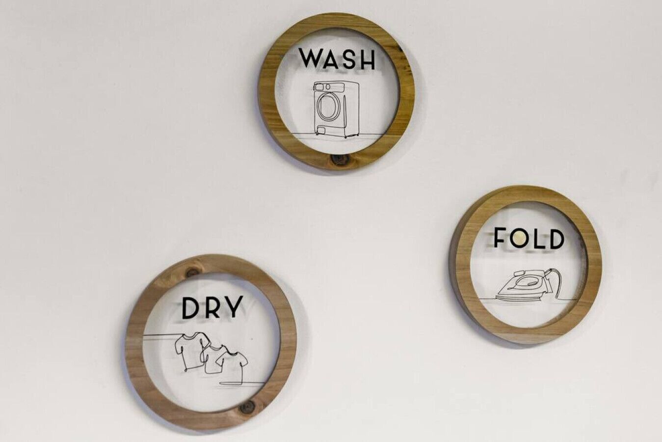 Three circular wall decorations with the words "WASH," "DRY," and "FOLD" along with corresponding icons.