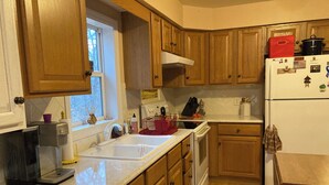 A kitchen with wooden cabinets, a sink, a stove, and a refrigerator. - Cozy house in quiet SML community. Close to State Park, wineries, Bridgewater. (Moneta)