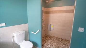 Ein Badezimmer mit Toilette, Dusche und Fliesenboden.