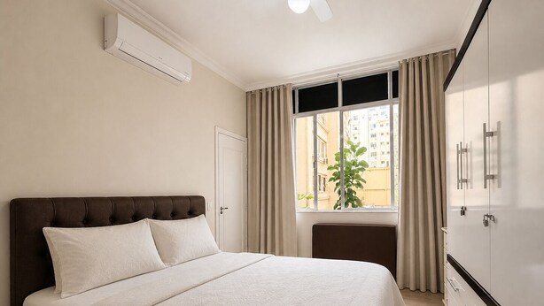 Une chambre avec un lit, une armoire, une fenêtre avec des rideaux et un appareil de climatisation.
