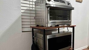 Een keuken met een inbouwoven en magnetron op een houten karretje.
