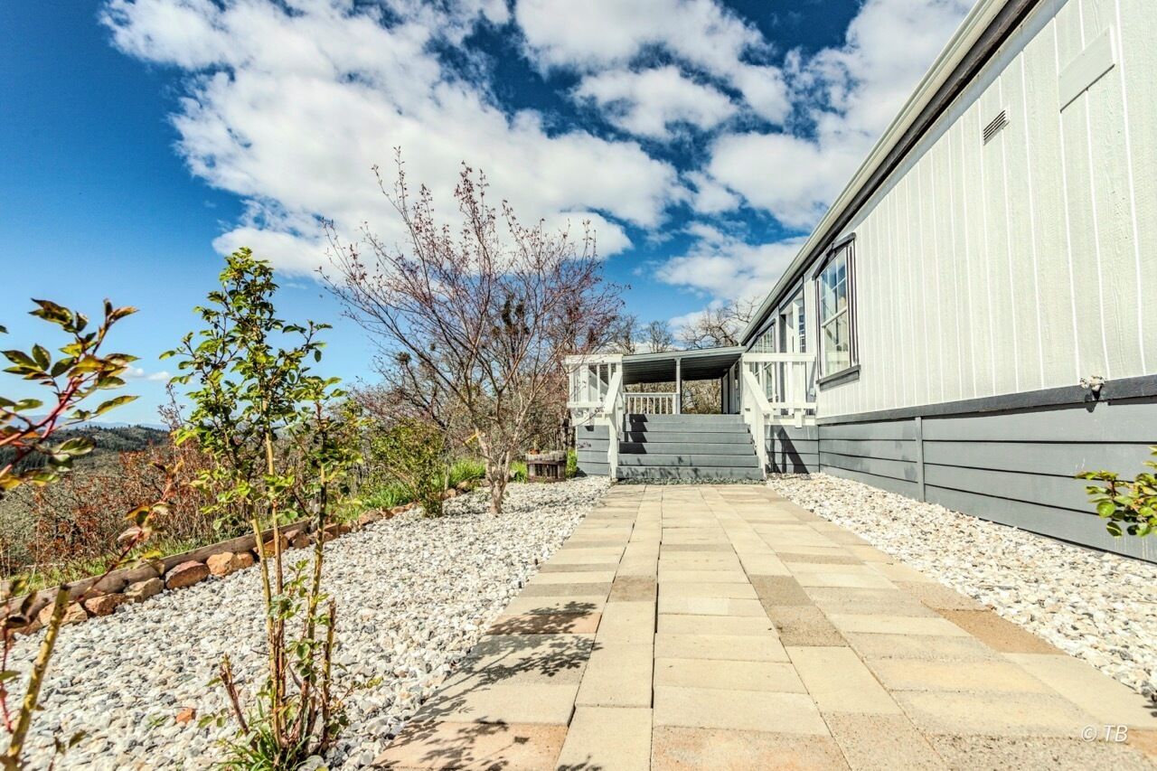 A pathway leading to a building with a covered staircase and a view of the sky.