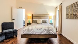 A bedroom with a bed, bedside lamps, a chair, and a decorative wall piece. - Stunning View, Fully Stocked Kitchen Near Wineries (Grants Pass)