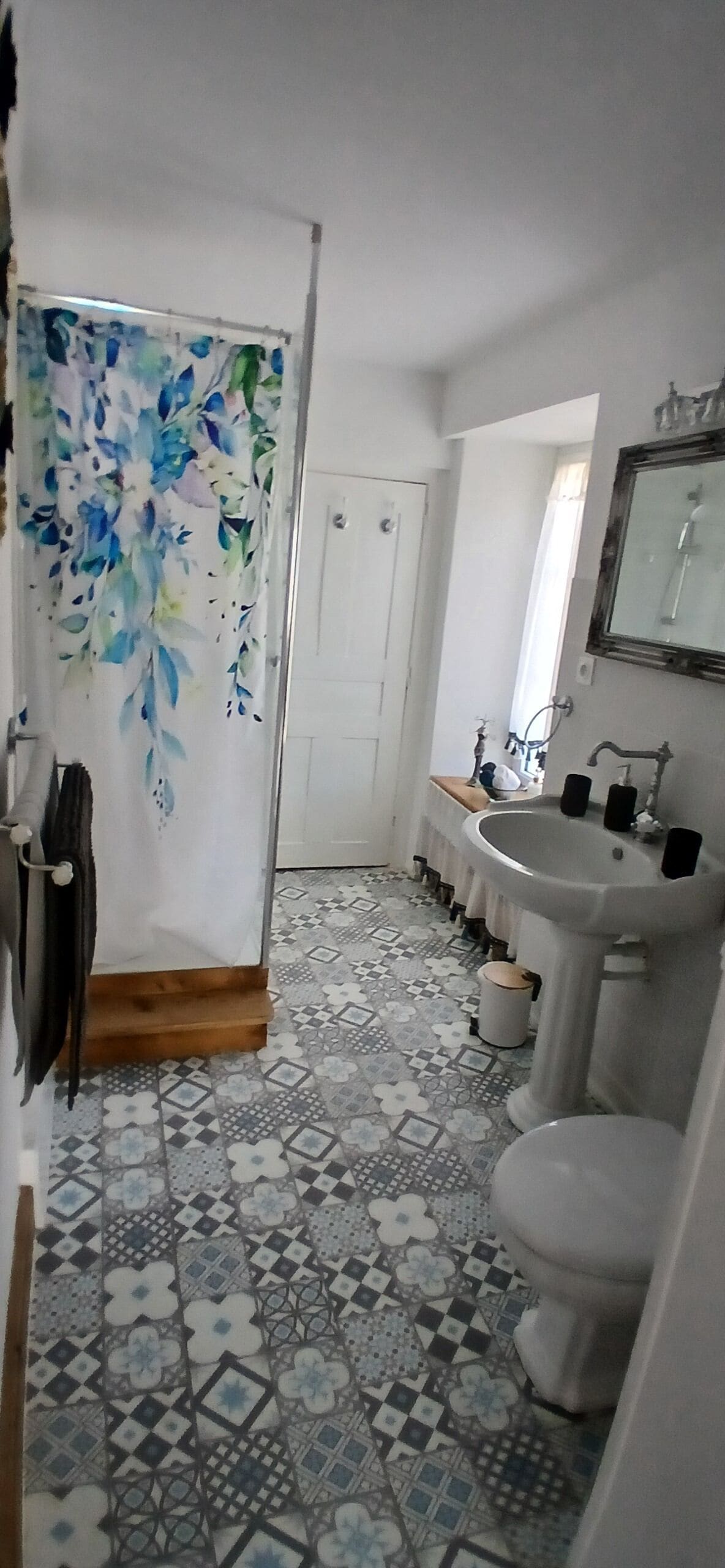 Une salle de bain avec un rideau de douche, un lavabo et des toilettes.