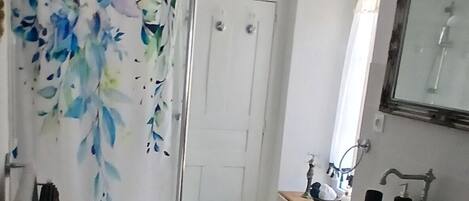A bathroom with a shower curtain, a sink, and a toilet.