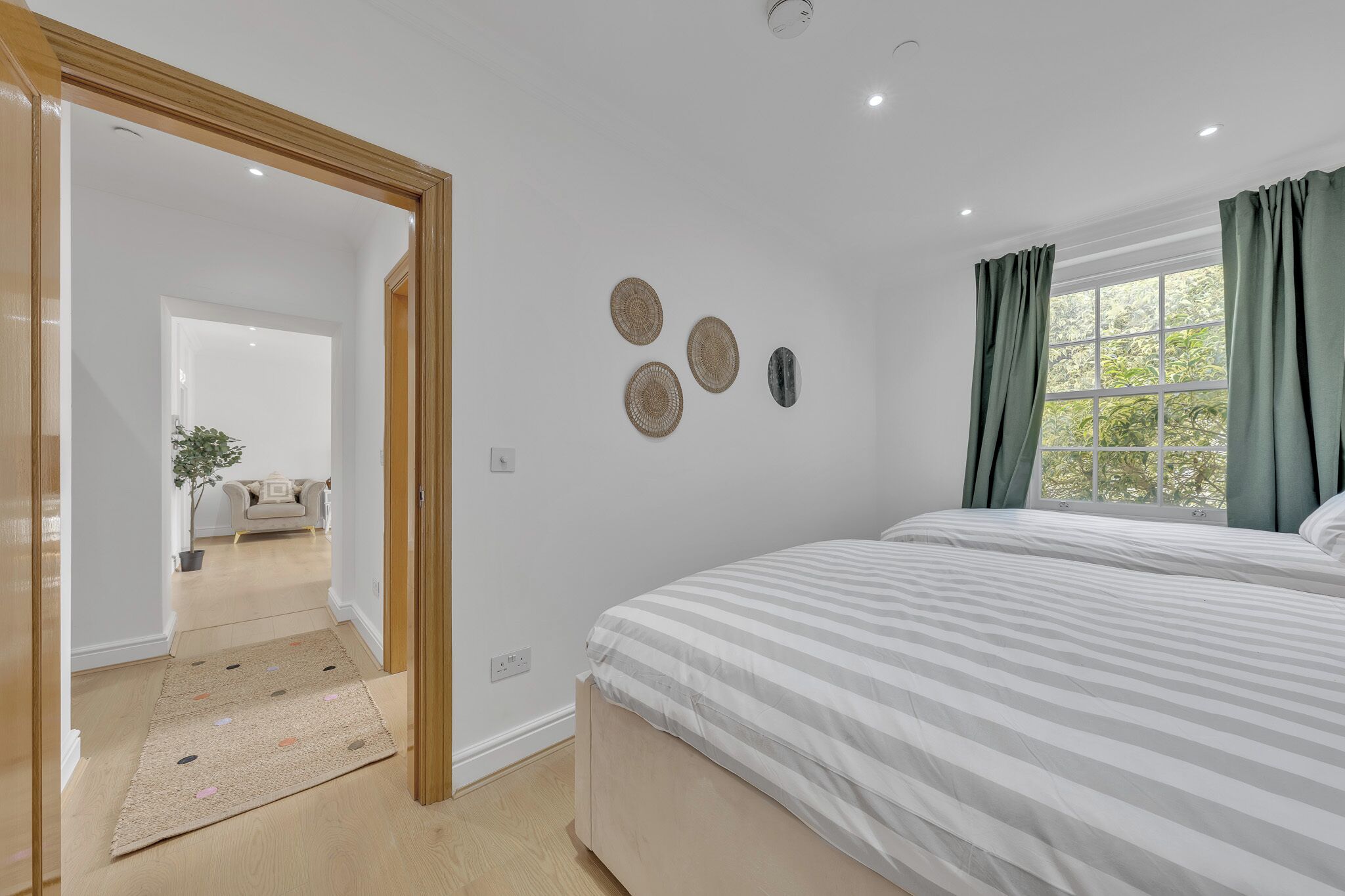 Ein Schlafzimmer mit Bett, Fenster mit Vorhängen und Wanddekorationen.