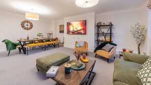 Ein modernes Wohnzimmer mit Essbereich, einer Couch, einem Couchtisch und einem Bücherregal.