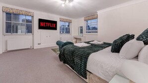 Ein Schlafzimmer mit Bett, Wandfernseher und Fenster mit Blick.