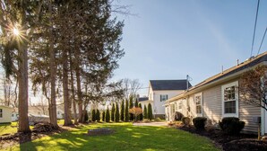 A residential area with a house, a well-maintained lawn, and several trees. - New! Charming Home in the Heart of Bemus Point, Lake Chautauqua, NY (Bemus Point)