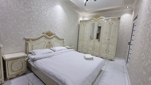 Cozy retreat with a large bed, wardrobe, and mirror.