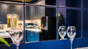 A modern kitchen with dark cabinets, a black refrigerator, and a marble countertop. - Large 5 Bedroom Home perfect for groups (Salford)