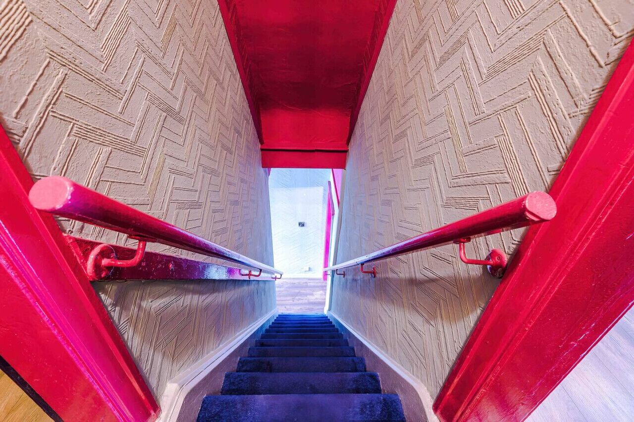 Una scala con ringhiere rosse e pareti in legno.