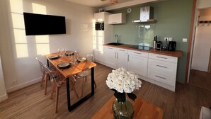 A modern kitchen with white cabinets, a wooden countertop, and a built-in oven.