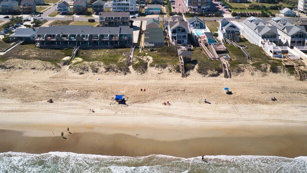 A beach with houses and a lifeguard tower.