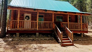 A log cabin with a porch and a staircase leading to the entrance.