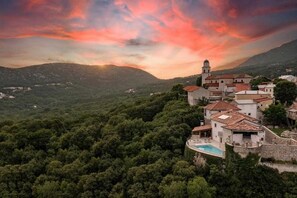 A hillside village with traditional architecture, a prominent bell tower, and a swimming pool. - Castle with Stunning Views by Aneo Travel (Bribir)