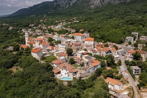 A village with traditional architecture, a central square, and a swimming pool. - Castle with Stunning Views by Aneo Travel (Bribir)