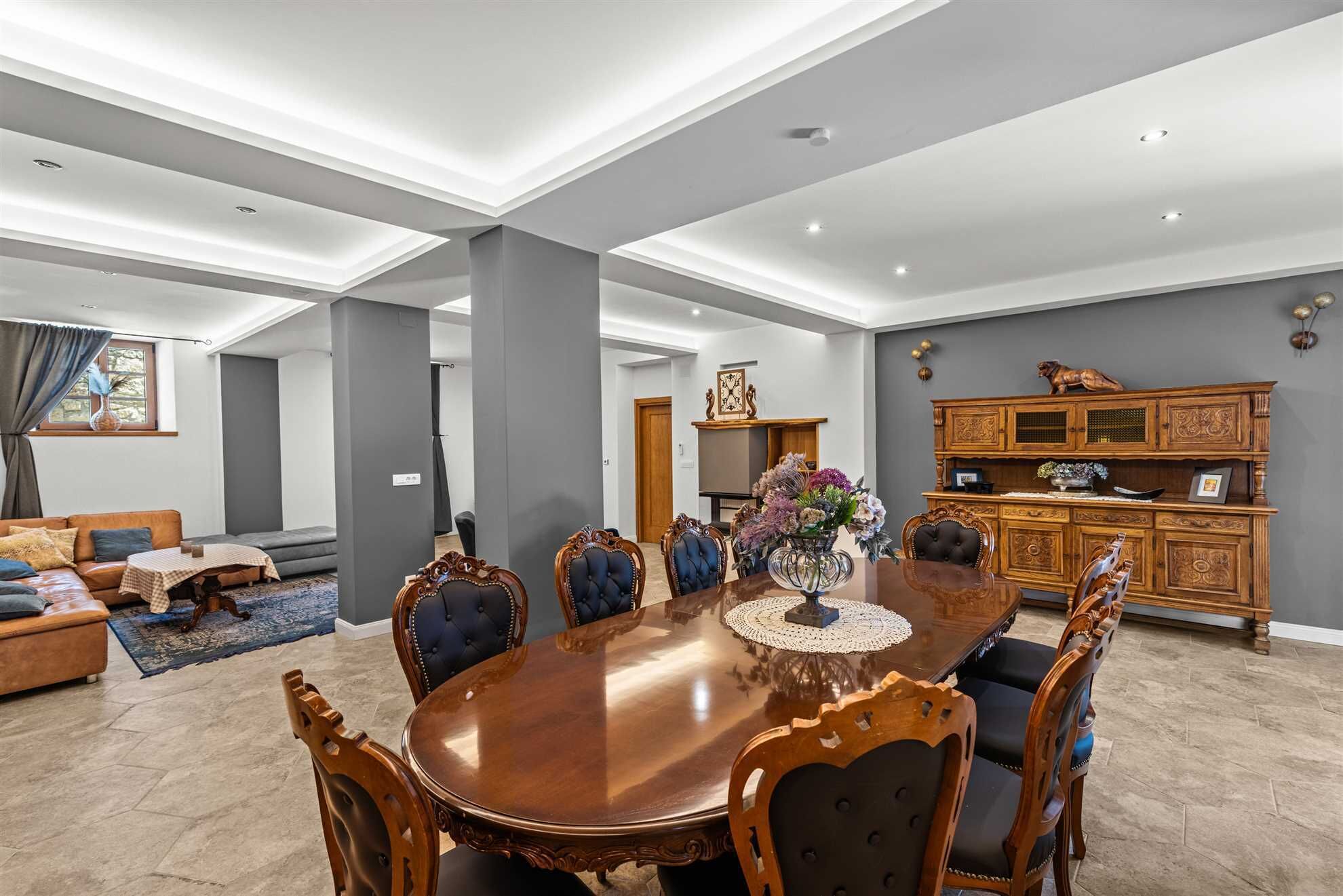 Un salon spacieux avec une grande table à manger en bois, des sièges confortables et un meuble décoratif.