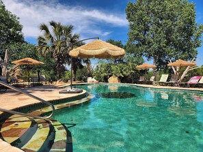 A clear blue pool with lounge chairs and thatched umbrellas. - ★The BIG HAUS-Texas Oasis★
The LARGEST HOUSE in Comal Co.!
Weddings, Events, etc (New Braunfels)