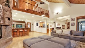 A spacious living area with a high ceiling, wooden staircase, and a cozy seating area. - THE SPA AT Winterset #2282 (Big Bear Lake)