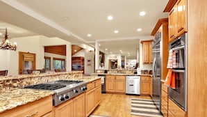 A spacious kitchen with granite countertops, wooden cabinets, stainless steel appliances, and a central island. - THE SPA AT Winterset #2282 (Big Bear Lake)