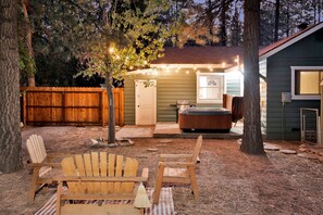 Ein Garten mit Whirlpool, Holzstühlen und einer Holzterrasse.