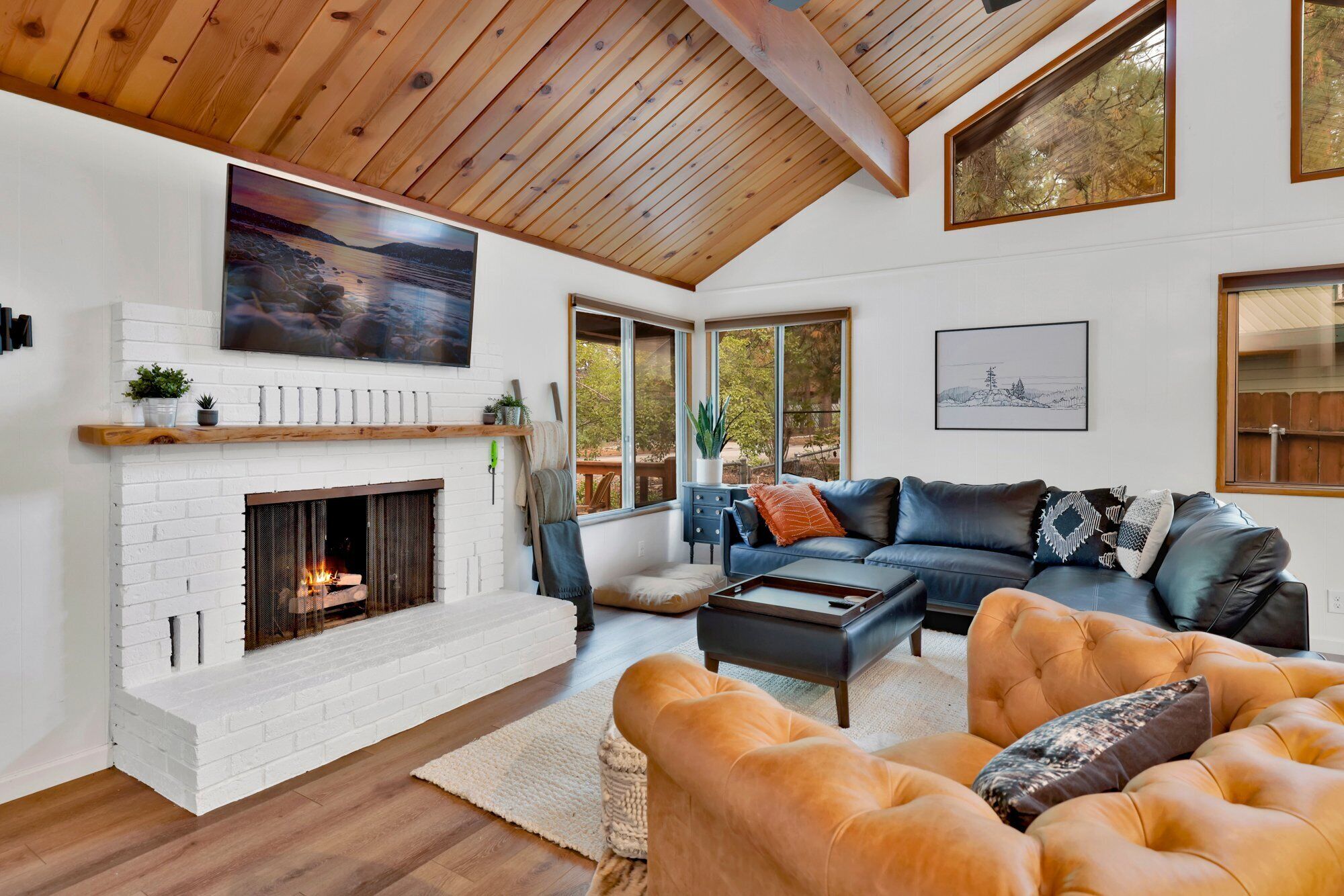 Una sala de estar moderna con chimenea, un televisor grande y una zona de estar acogedora.