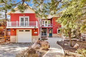 A two-story red house with a white balcony, a garage, and a paved driveway. - THE Grand Chalet #1989 (Big Bear Lake)