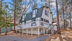 A two-story house with a balcony, surrounded by trees and a driveway. - Pinewood INN #2093 (Big Bear City)