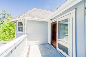 Une maison moderne dotée d’un porche abrité, de grandes portes-fenêtres coulissantes et d’une fenêtre bien visible.