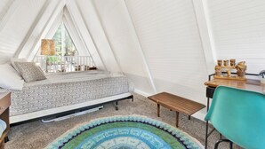 A tent-style room with a bed, a small table, and a chair. - Sunrise Cottage #1800 (Big Bear City)