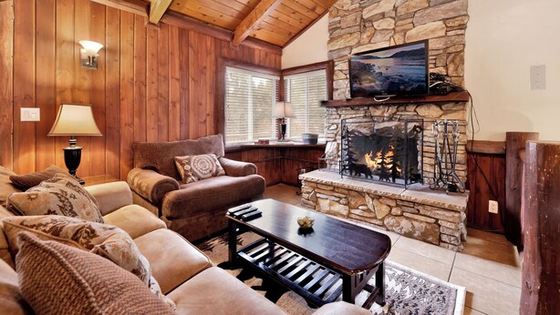A cozy living room with a stone fireplace, wooden ceiling beams, and a comfortable seating area. - Bear Tracks #2020 (Big Bear Lake)