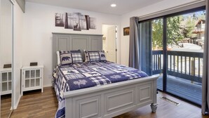 Una camera da letto con un letto grande, una finestra con vista sull'esterno e una porta che conduce a un'altra stanza.