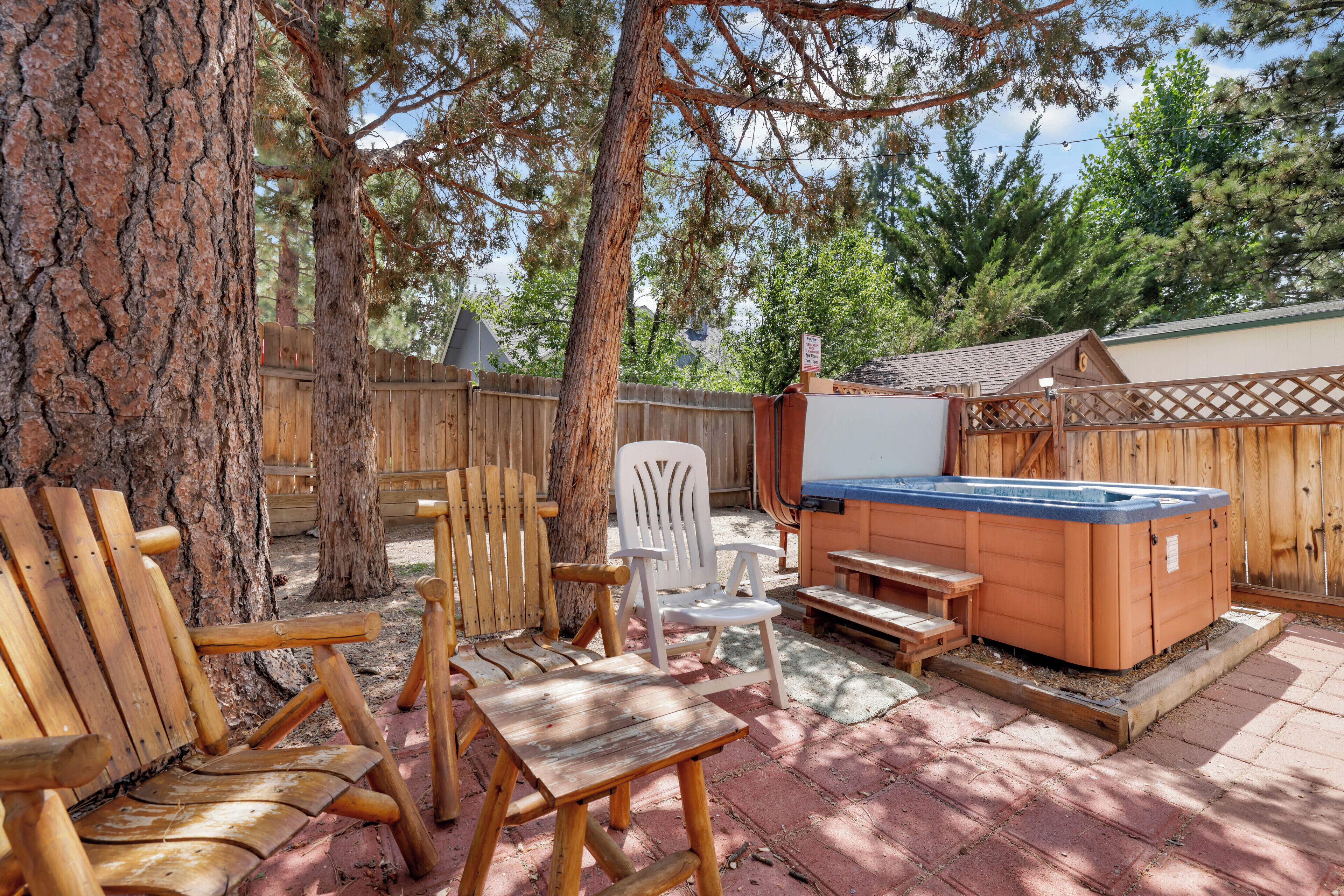 Un jardin avec un jacuzzi, une terrasse en bois et un coin salon extérieur.